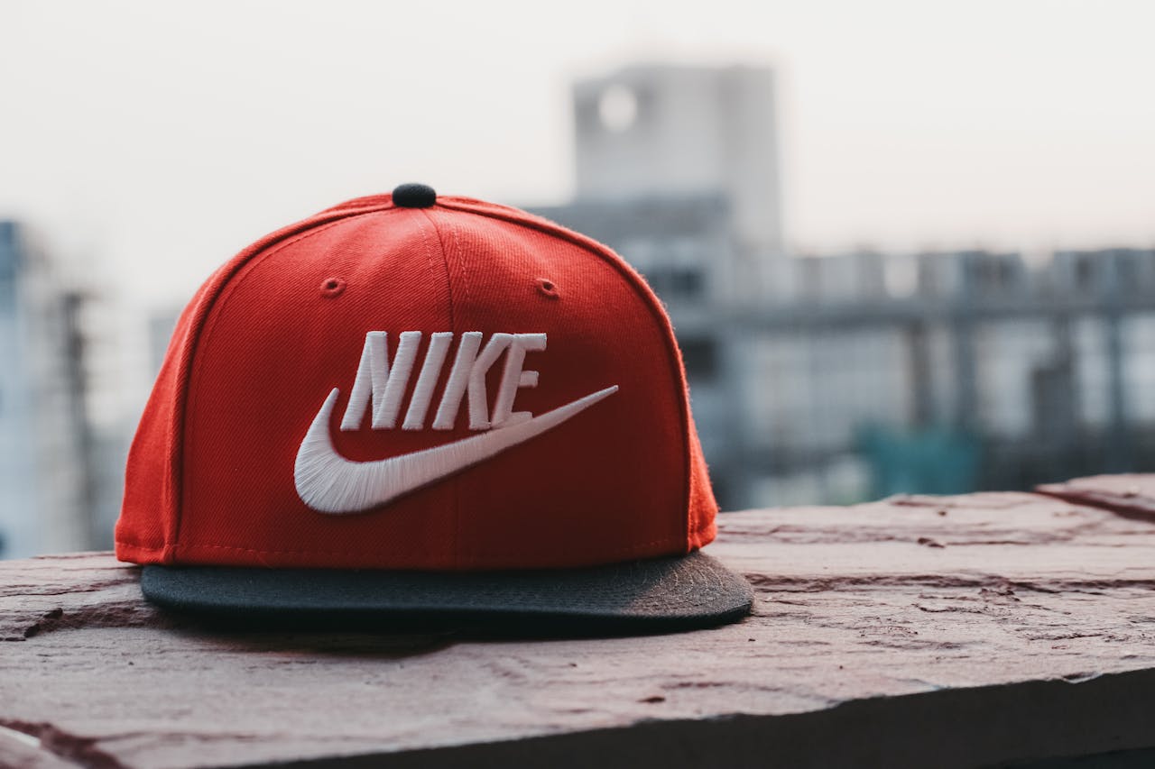 hero-img-02 Red cap with logo on a rooftop against an urban cityscape backdrop in daylight.