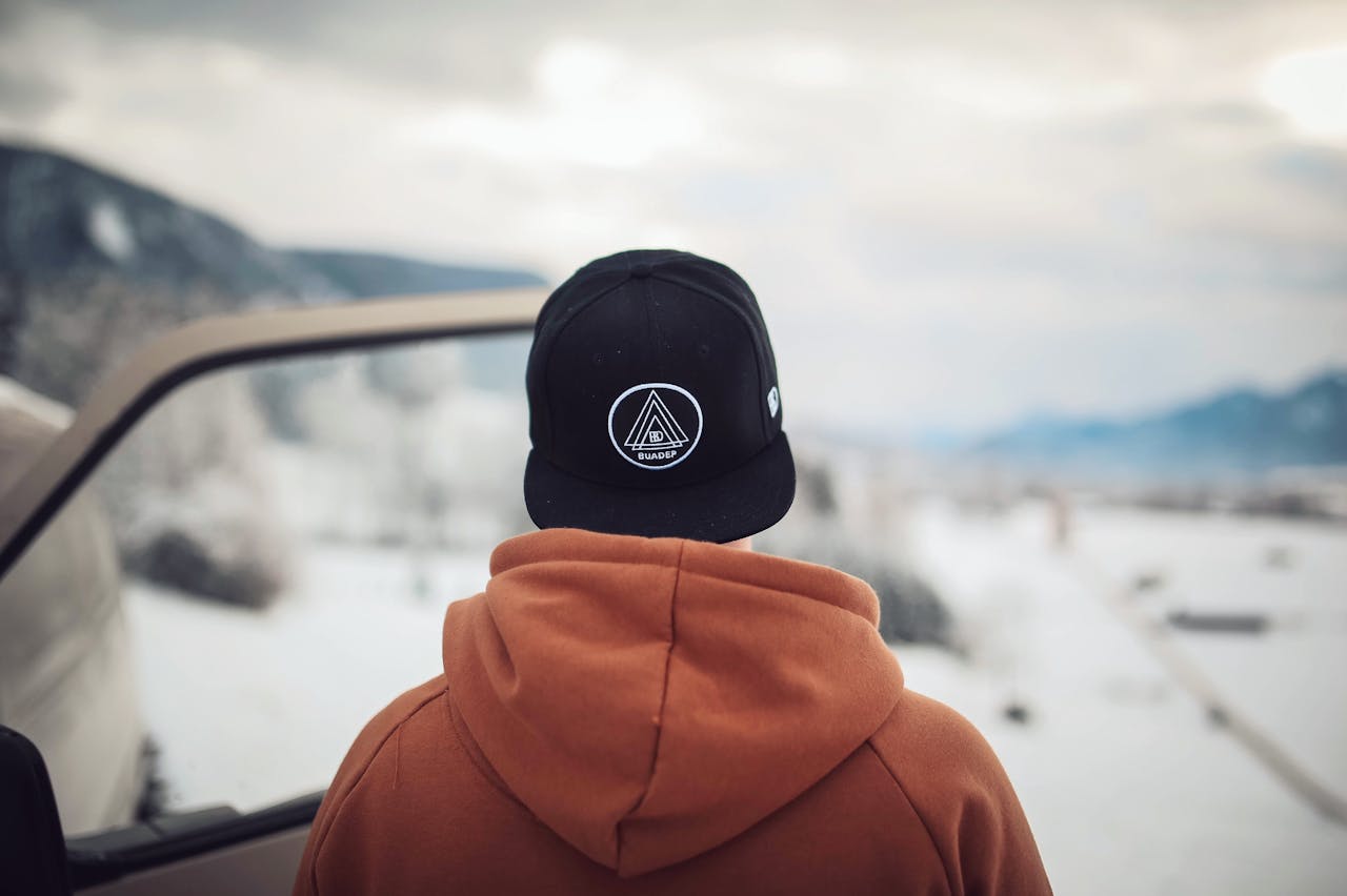 about-01 A person stands by a car in snowy Ohlstadt, Germany, admiring winter mountains.
